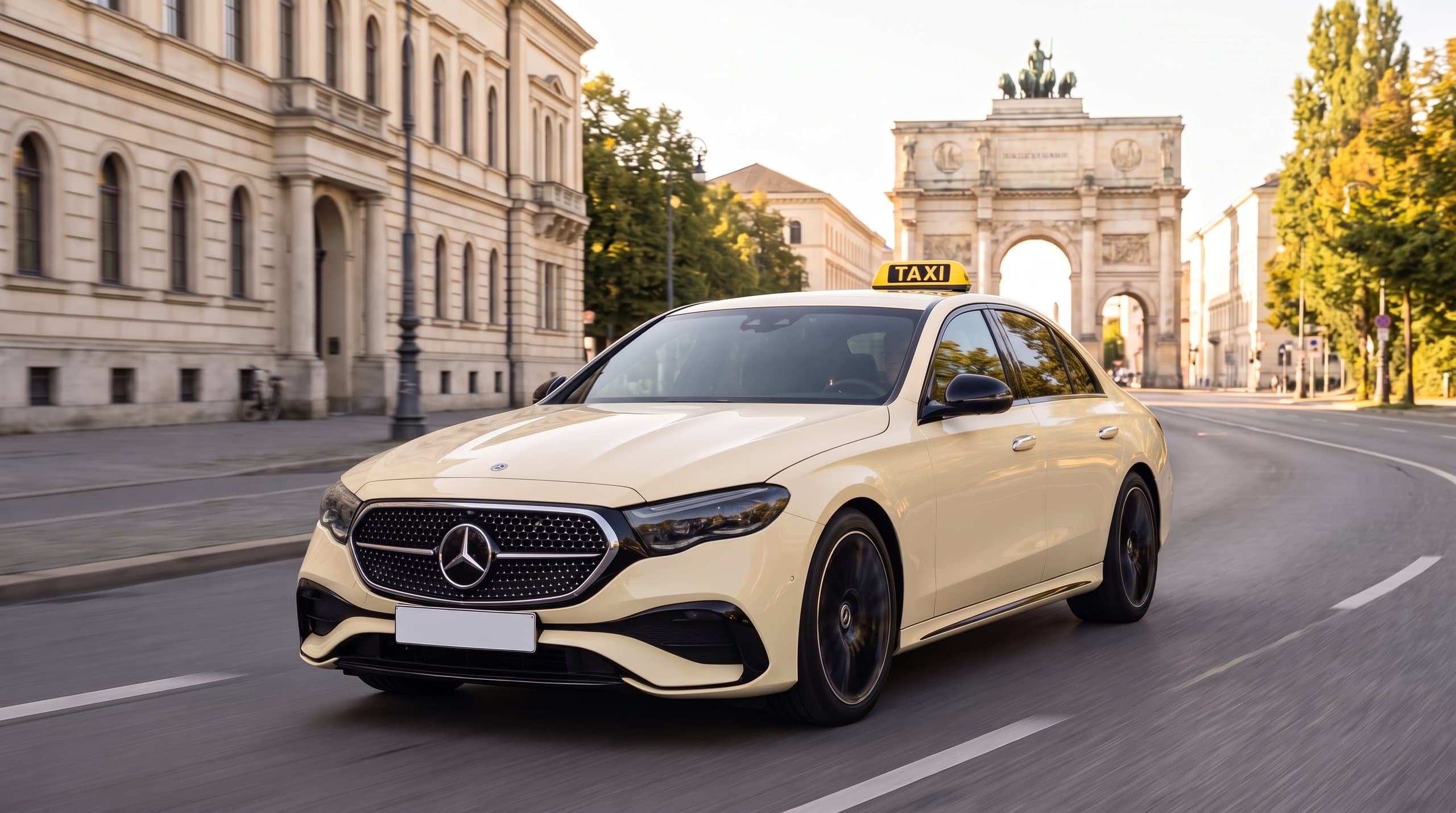 Elfenbeinfarbene Limousine als Taxi auf der Ludwigstraße in München, im Hintergrund das Siegestor bei Tageslicht
